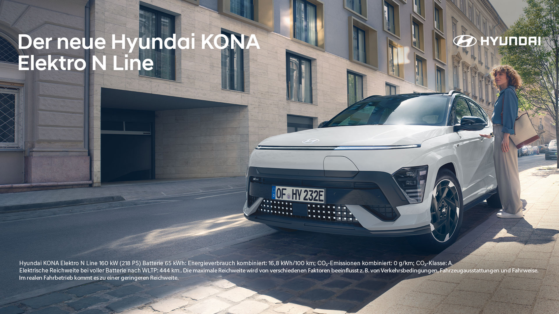 zu sehen ist ein weißer Hyundai Kona, eine Frau steht daneben