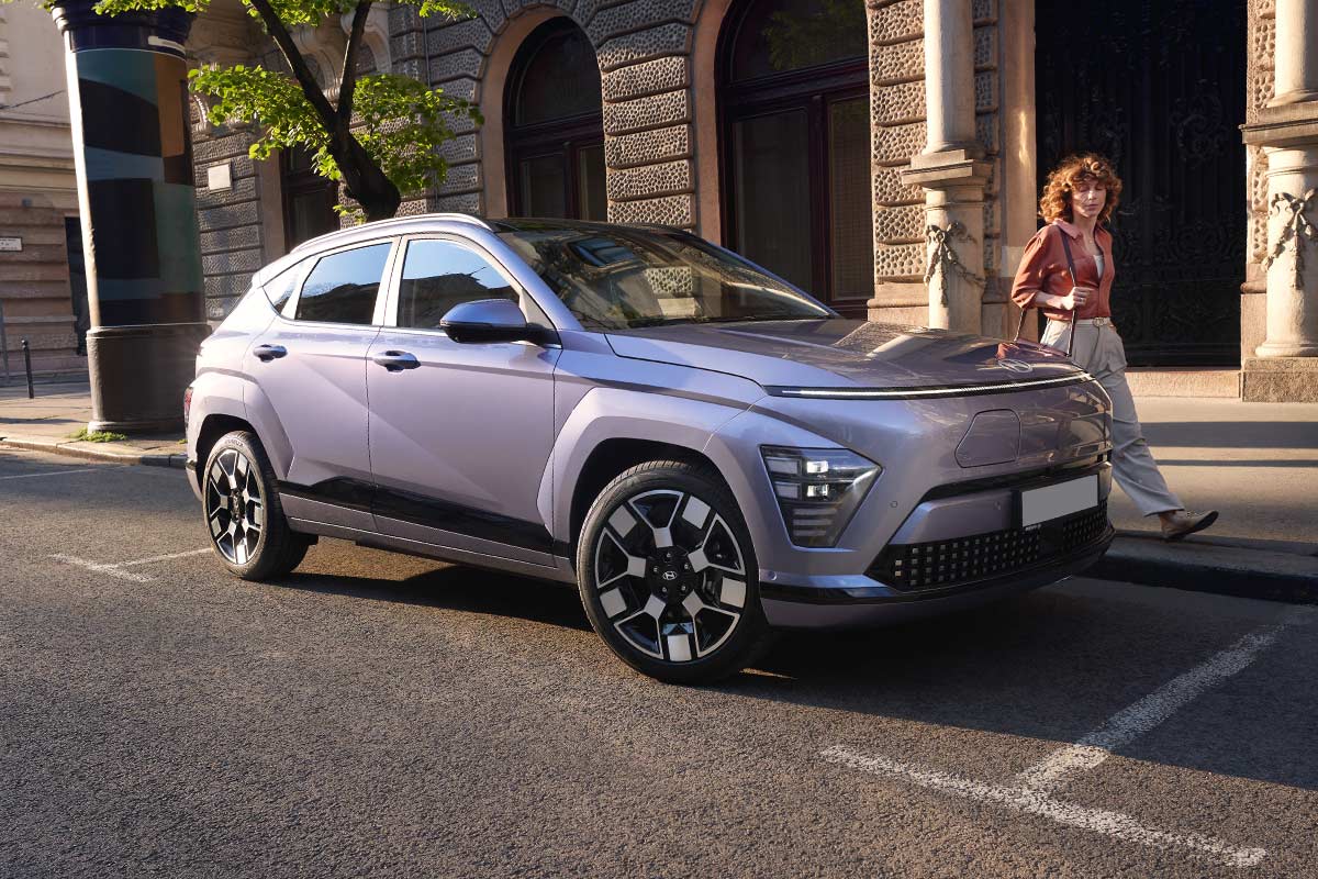 Hyundai Kona Elektro mit Frau die vorbei geht.