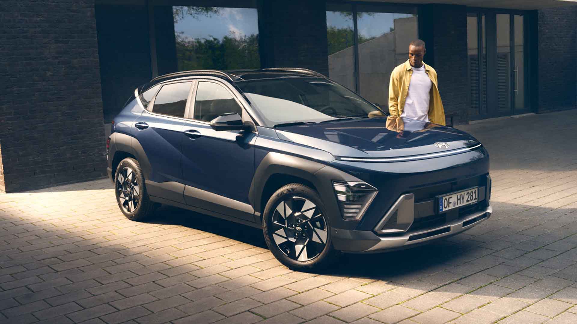 blauer Hyundai Kona, rechts steht ein Mann