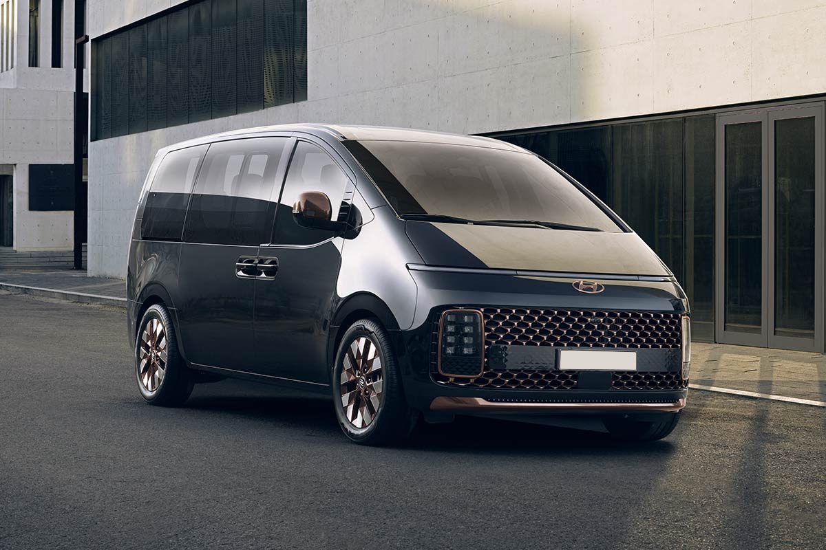 Hyundai Staria 7 Sitzer parkt vor einem modernem Wohnblock