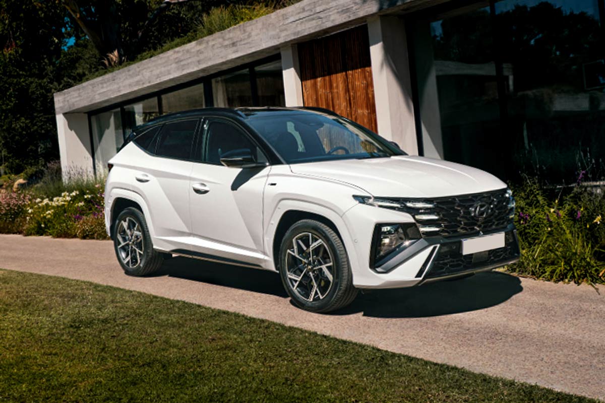 Hyundai Tucson Hybrid parkt an einem Hang vor einem Haus